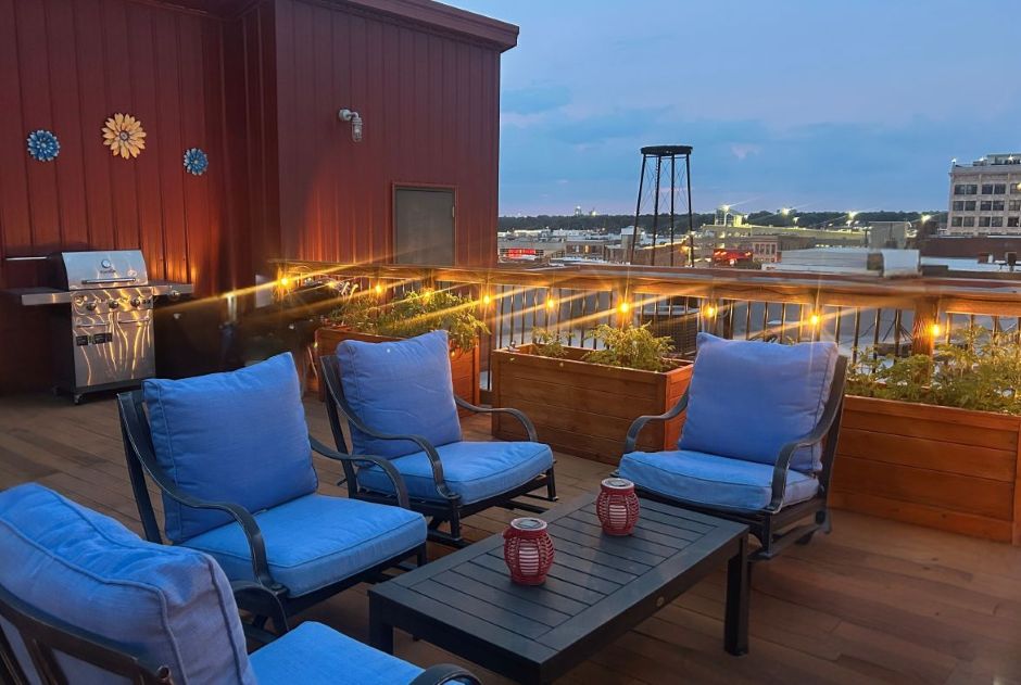 Rooftop deck light at night with patio furniture